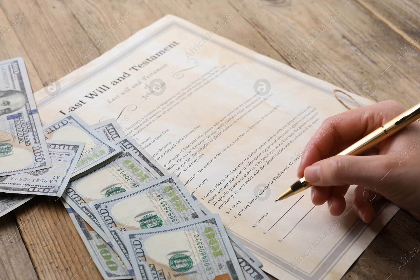 Photo of Woman signing Last Will and Testament at wooden table, closeup