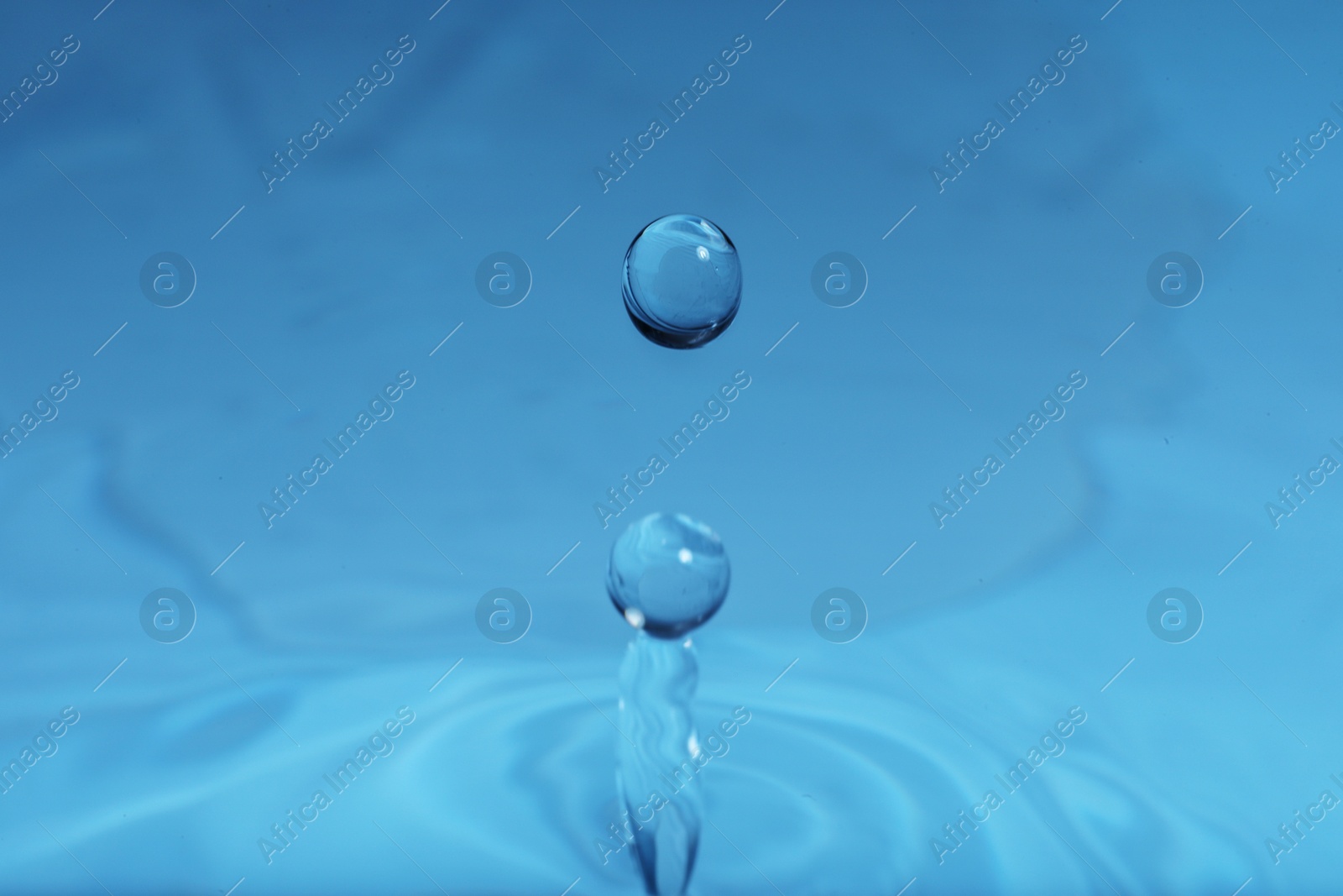 Photo of Splash of blue water with drop, macro view