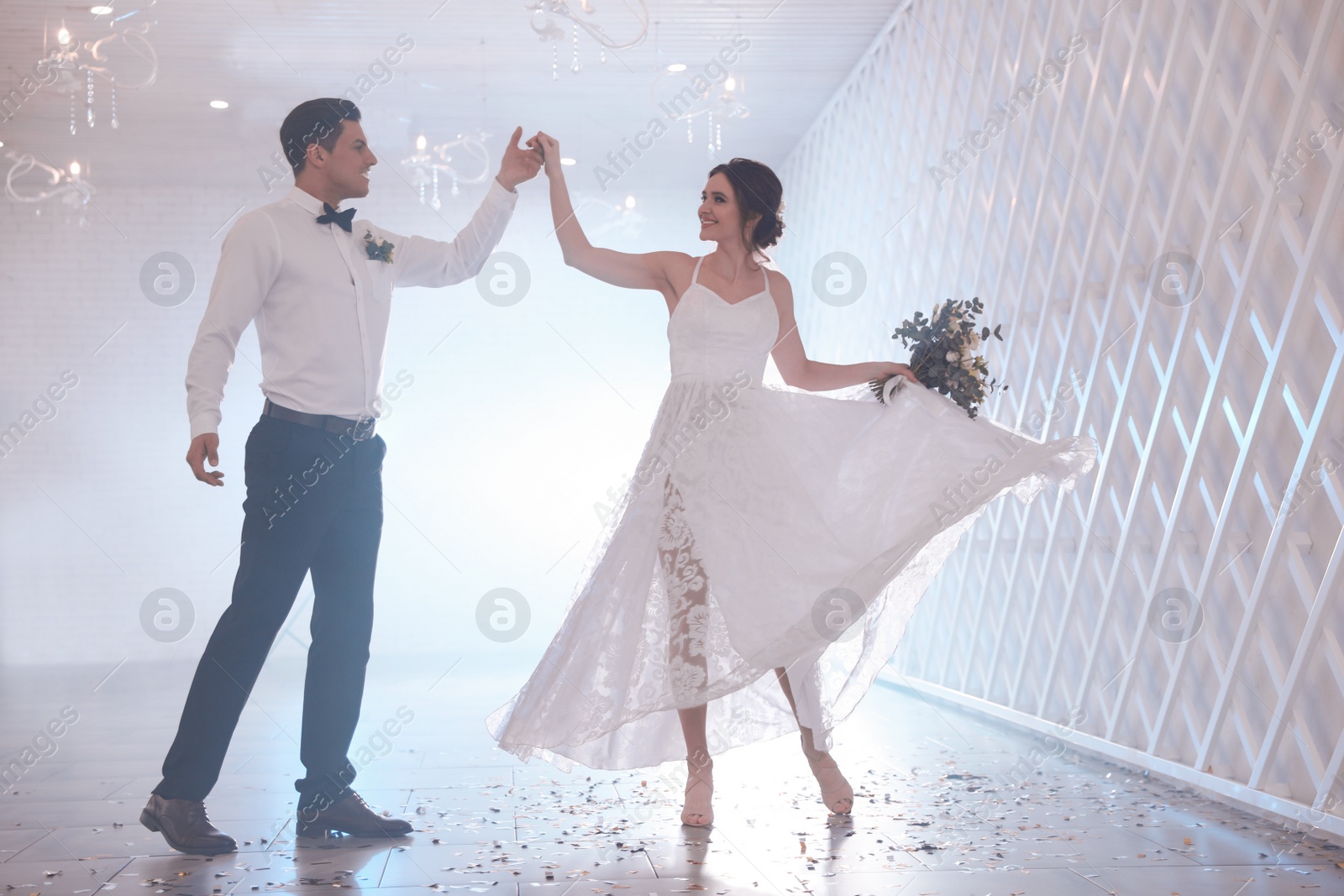 Photo of Happy newlywed couple dancing together in festive hall