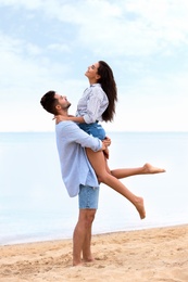 Photo of Happy young couple spending time together on beach near sea