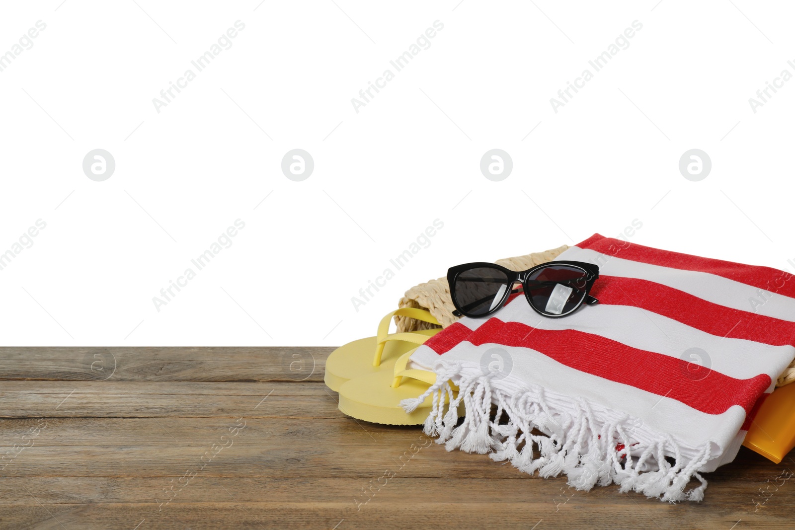 Photo of Beach bag with towel, flip flops and sunglasses on wooden surface against white background. Space for text