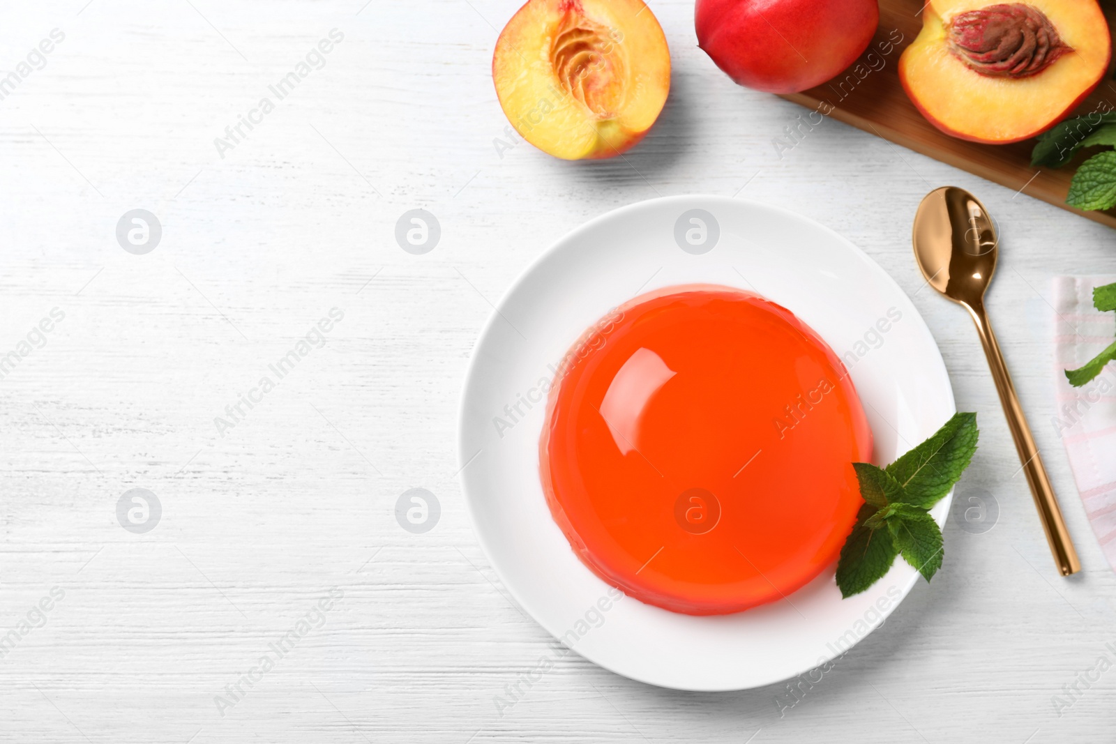 Photo of Delicious orange jelly with mint on white wooden table, flat lay. Space for text