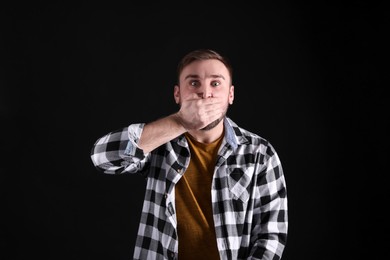 Photo of Portrait of emotional young man on black background. Personality concept