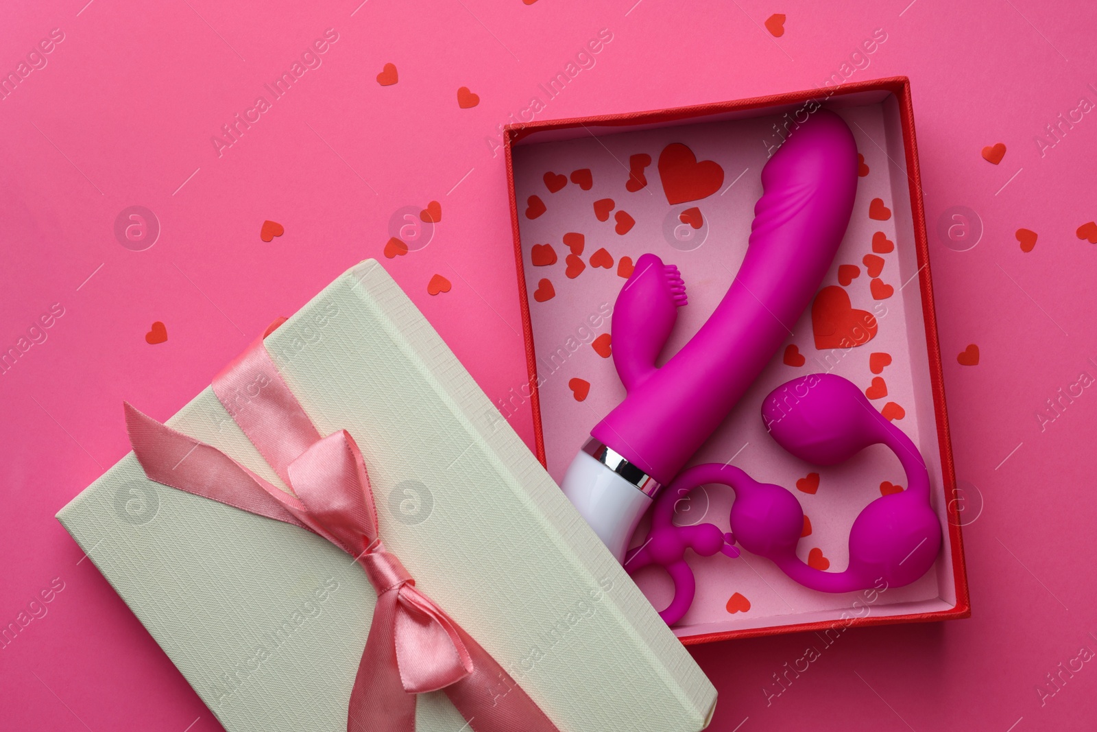 Photo of Gift box with sex toys on pink background, top view