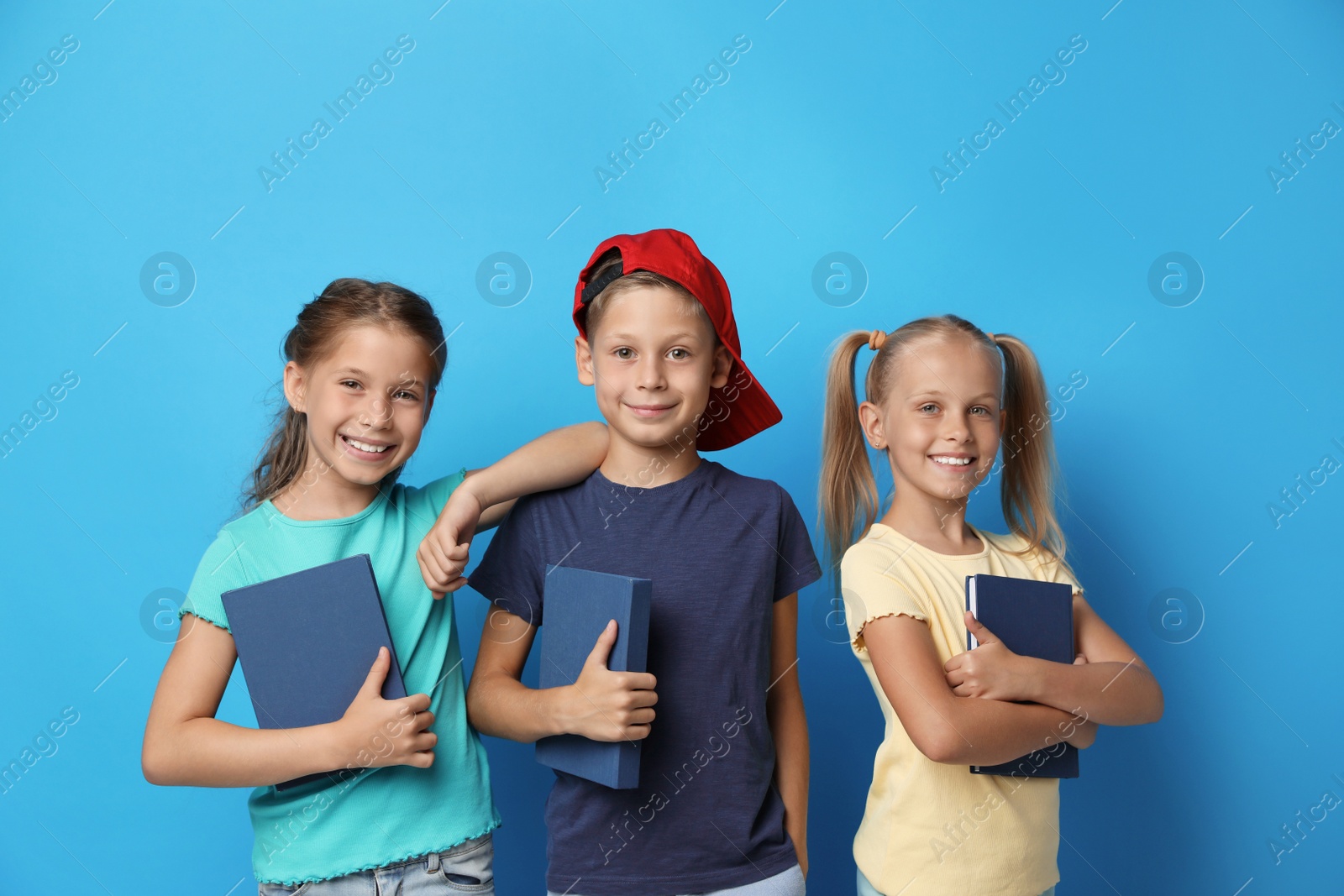 Photo of Little children with books on blue background. Reading concept