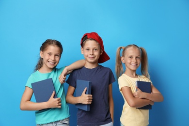 Photo of Little children with books on blue background. Reading concept