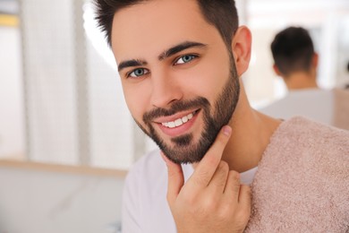 Handsome young man after shaving in bathroom, closeup