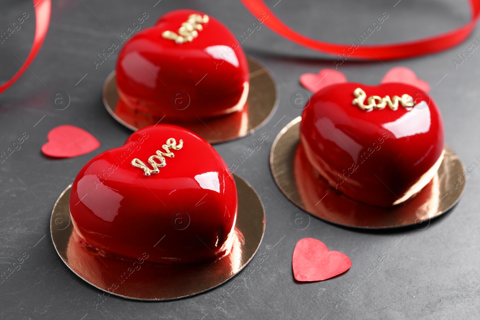 Photo of St. Valentine's Day. Delicious heart shaped cakes and confetti on black table, closeup