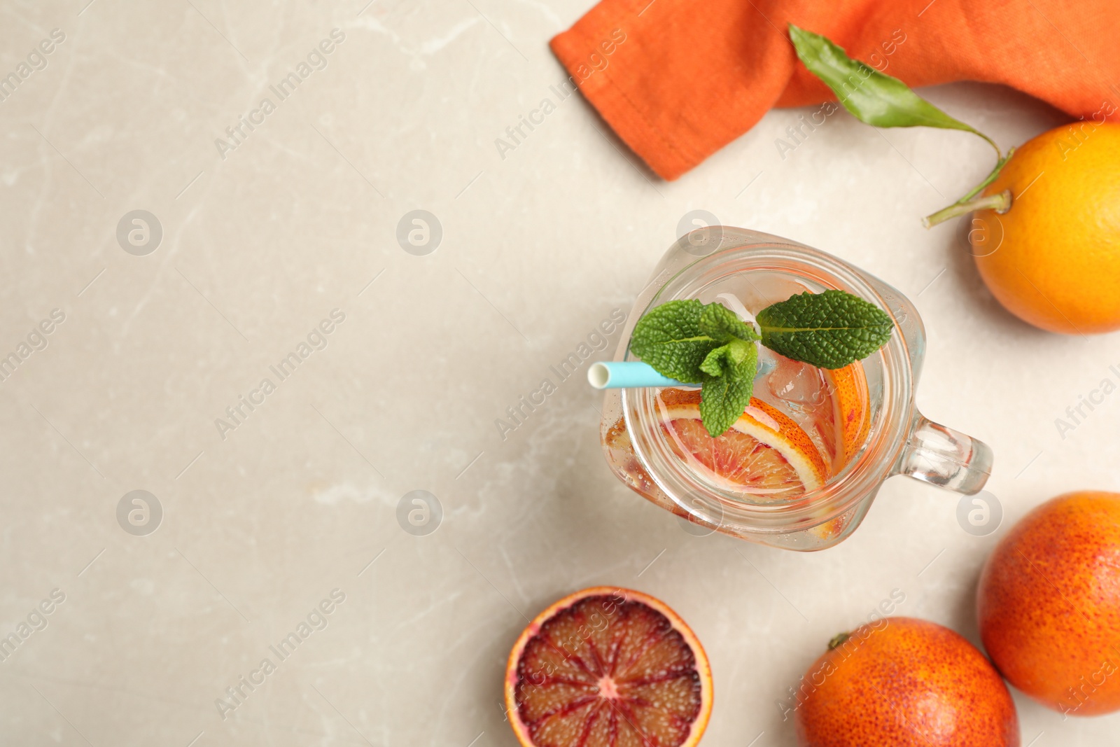 Photo of Delicious refreshing drink with sicilian orange and mint on grey table, flat lay. Space for text