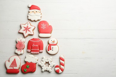 Christmas tree shape made of delicious gingerbread cookies on white wooden table, flat lay. Space for text