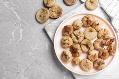 Tasty dried figs on light grey marble table, flat lay. Space for text