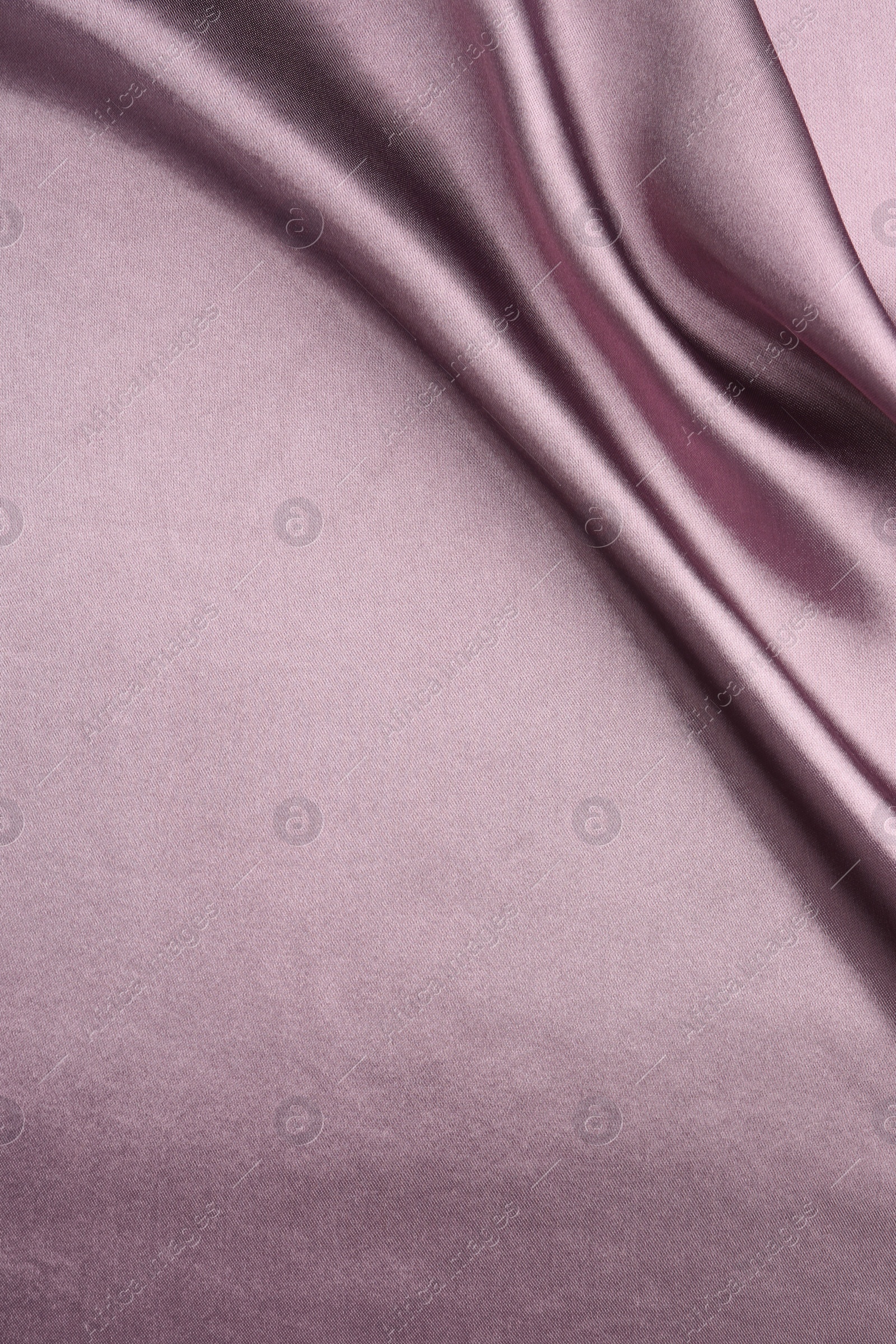 Photo of Crumpled dark purple silk fabric as background, top view. Space for text