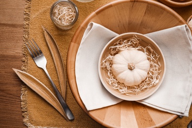 Photo of Autumn table setting with pumpkin and decor on wooden background, flat lay