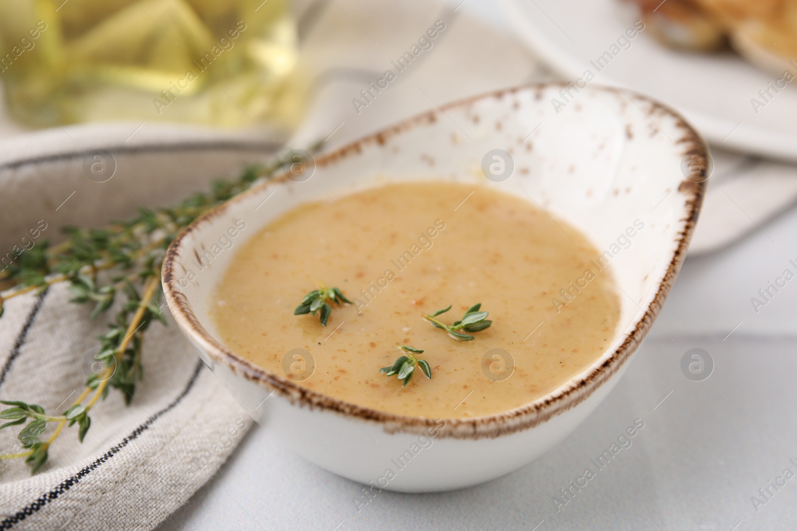 Photo of Delicious turkey gravy and thyme on white table, closeup