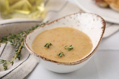 Photo of Delicious turkey gravy and thyme on white table, closeup