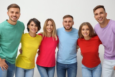 Photo of Group of young people hugging each other on light background. Unity concept