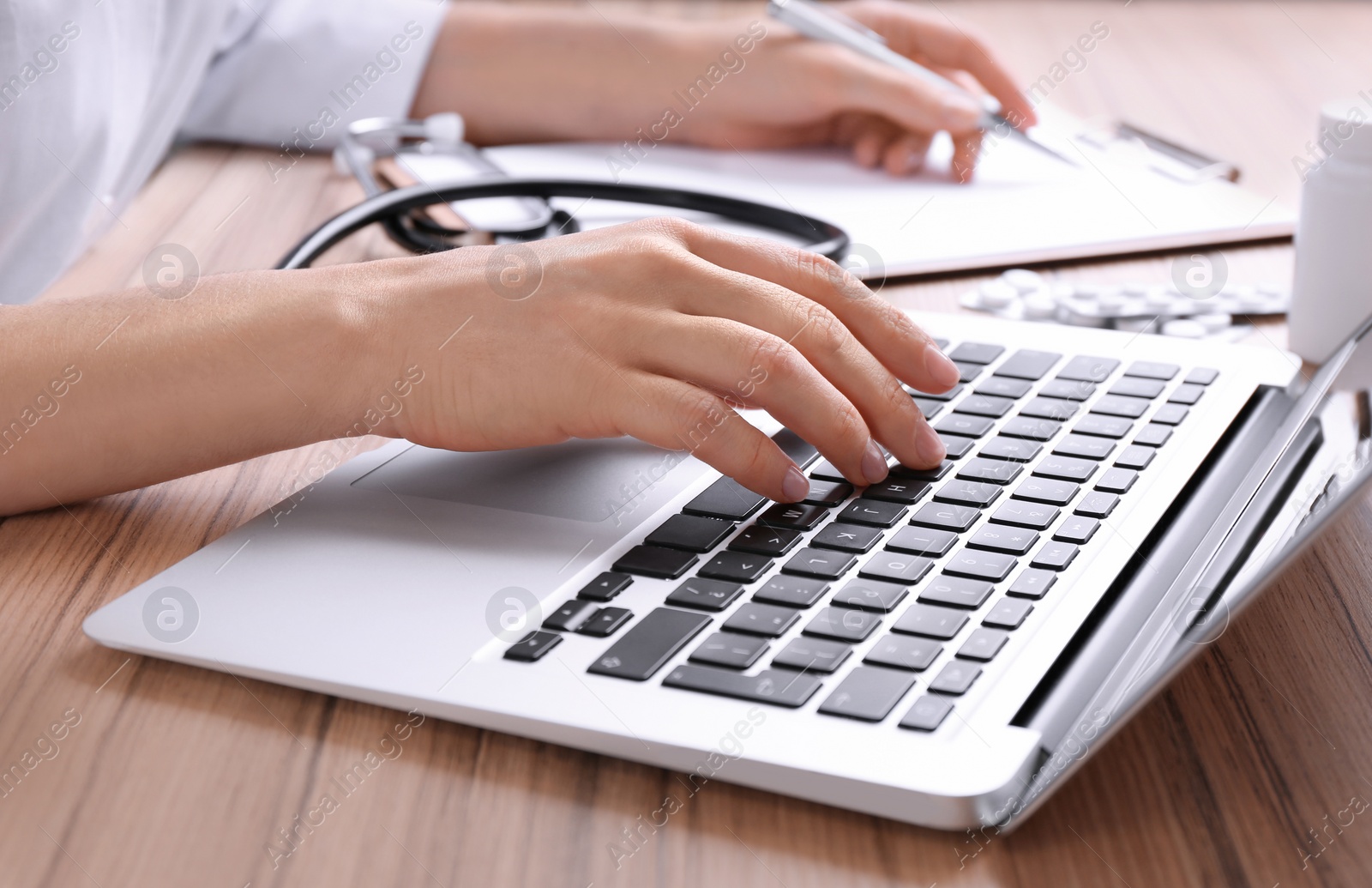 Photo of Doctor working with laptop at desk in office, closeup. Medical service