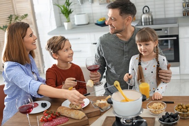 Happy family enjoying fondue dinner at home