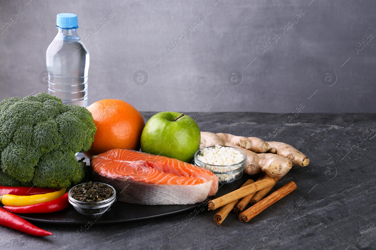 Photo of Metabolism. Different food products on grey table, space for text