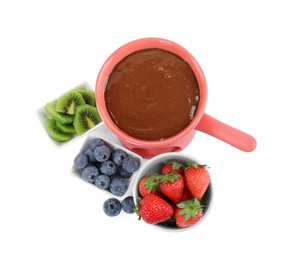 Photo of Fondue pot with melted chocolate, fresh berries and kiwi isolated on white, top view