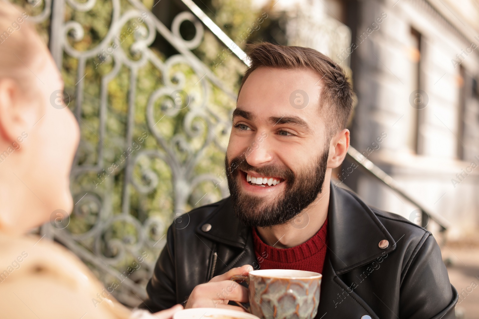 Photo of Lovely young couple enjoying tasty coffee outdoors