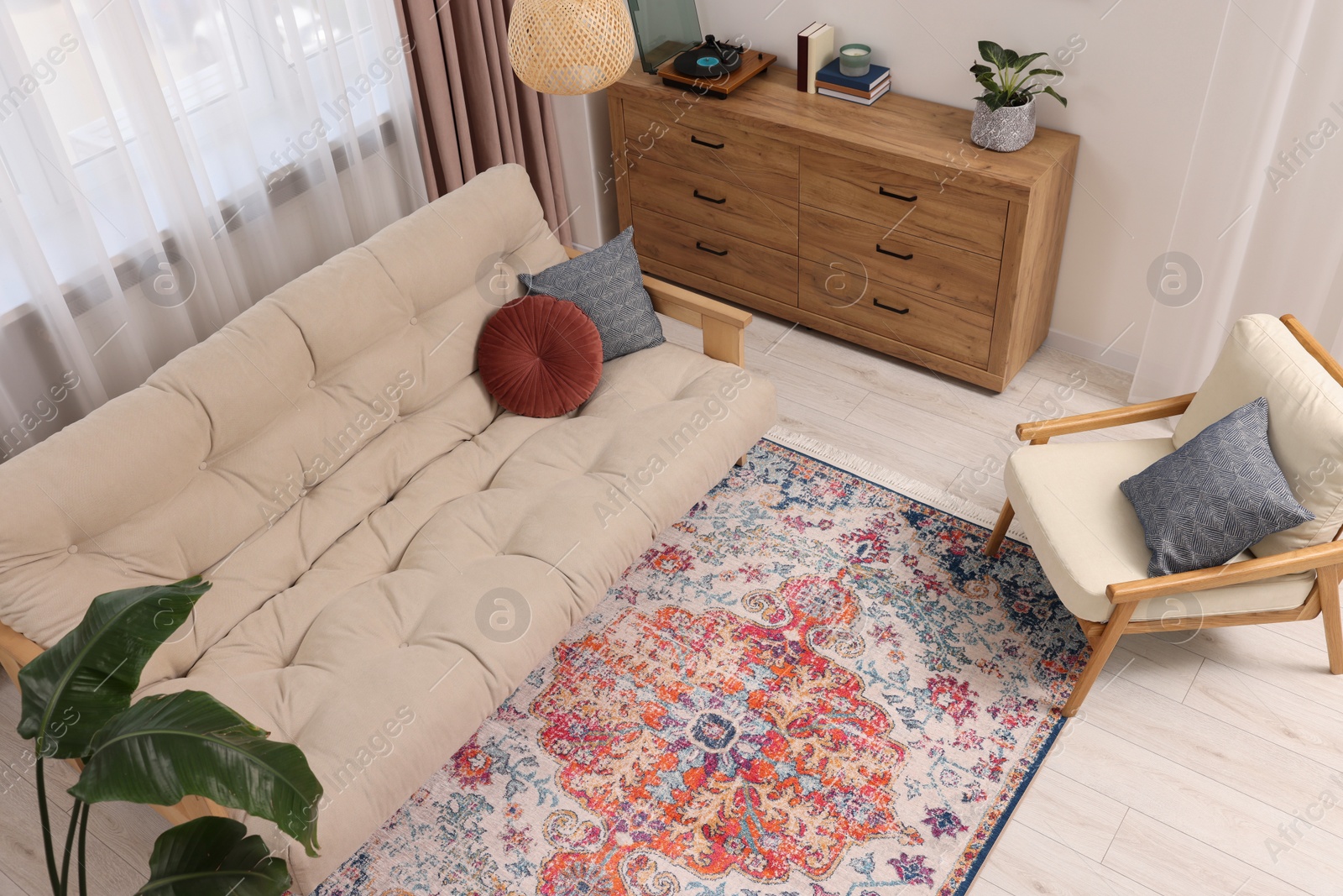 Photo of Beautiful rug, sofa, armchair and chest of drawers indoors, above view