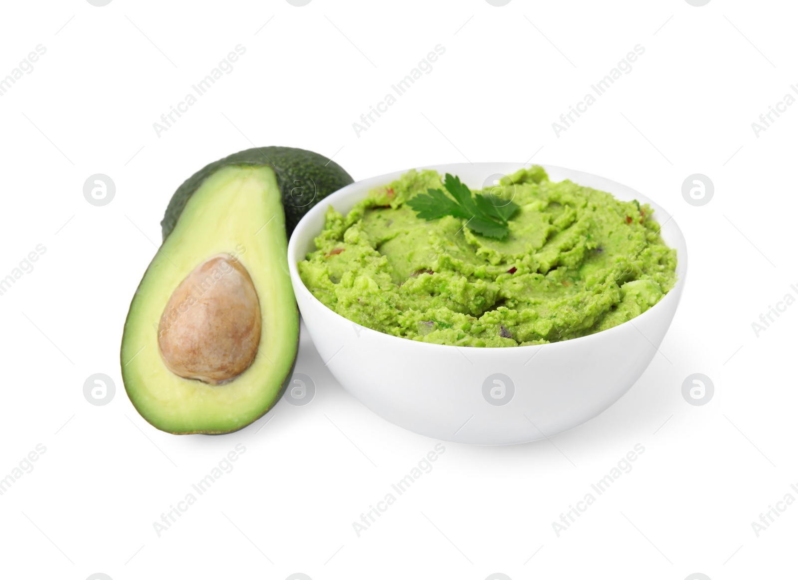 Photo of Bowl of delicious guacamole and fresh avocados isolated on white