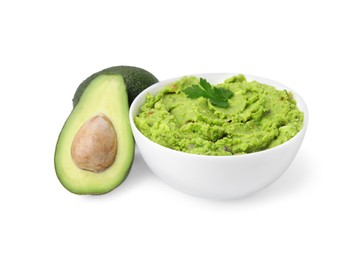 Bowl of delicious guacamole and fresh avocados isolated on white