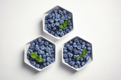 Photo of Flat lay composition with fresh blueberries and green leaves on table
