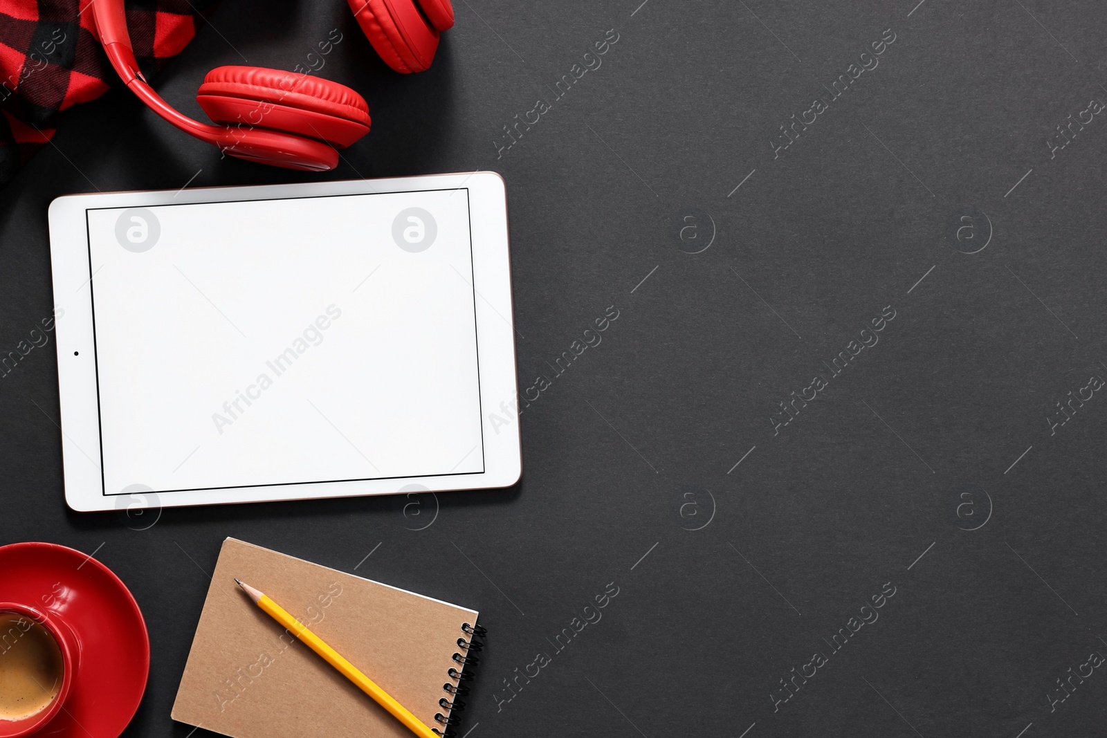 Photo of Modern tablet, notepad, headphones and coffee on black background, flat lay. Space for text