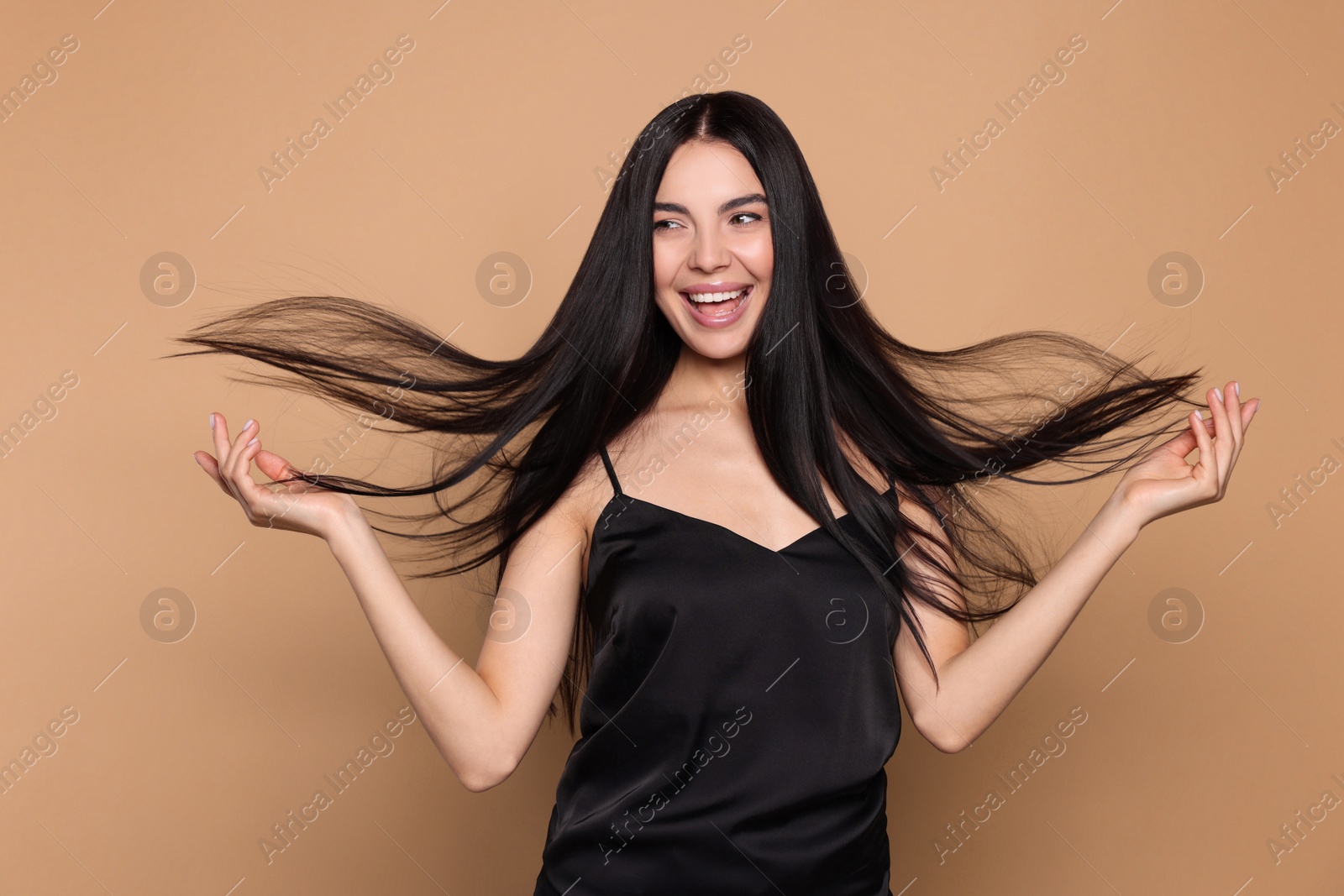 Photo of Portrait of beautiful young woman with healthy strong hair on beige background