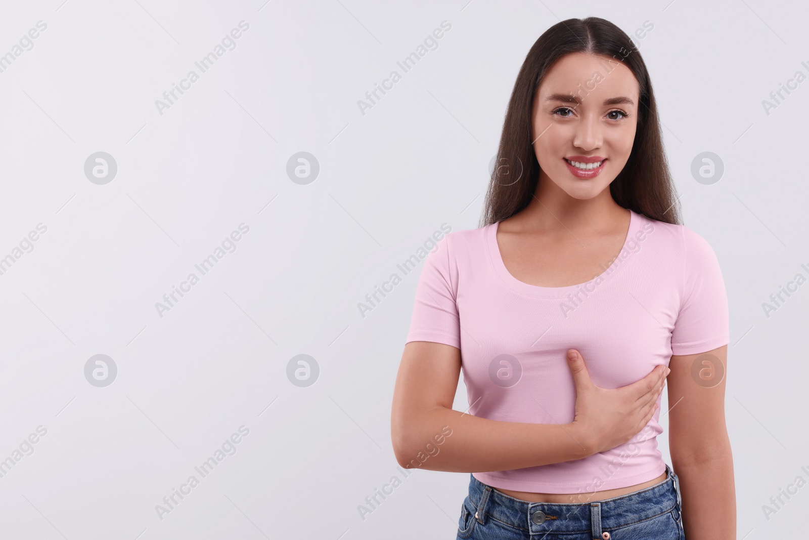 Photo of Beautiful happy woman doing breast self-examination on white background, space for text