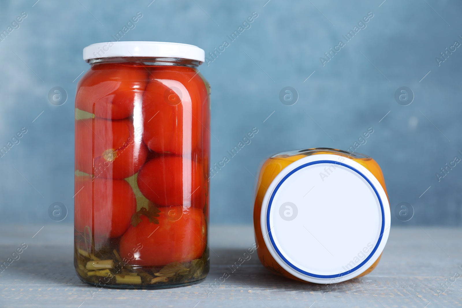 Photo of Glass jars with pickled vegetables on wooden table