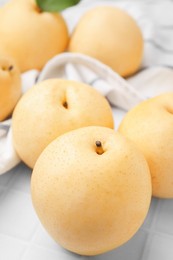 Photo of Delicious apple pears on white tiled table, closeup