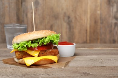 Delicious tofu burger served with sauce on wooden table. Space for text