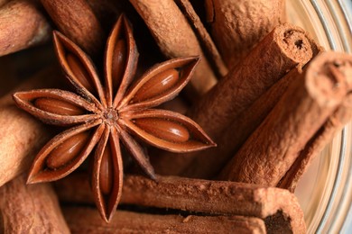 Photo of Aromatic cinnamon sticks and anise star in bowl, top view