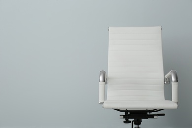Comfortable office chair on light background. Space for text