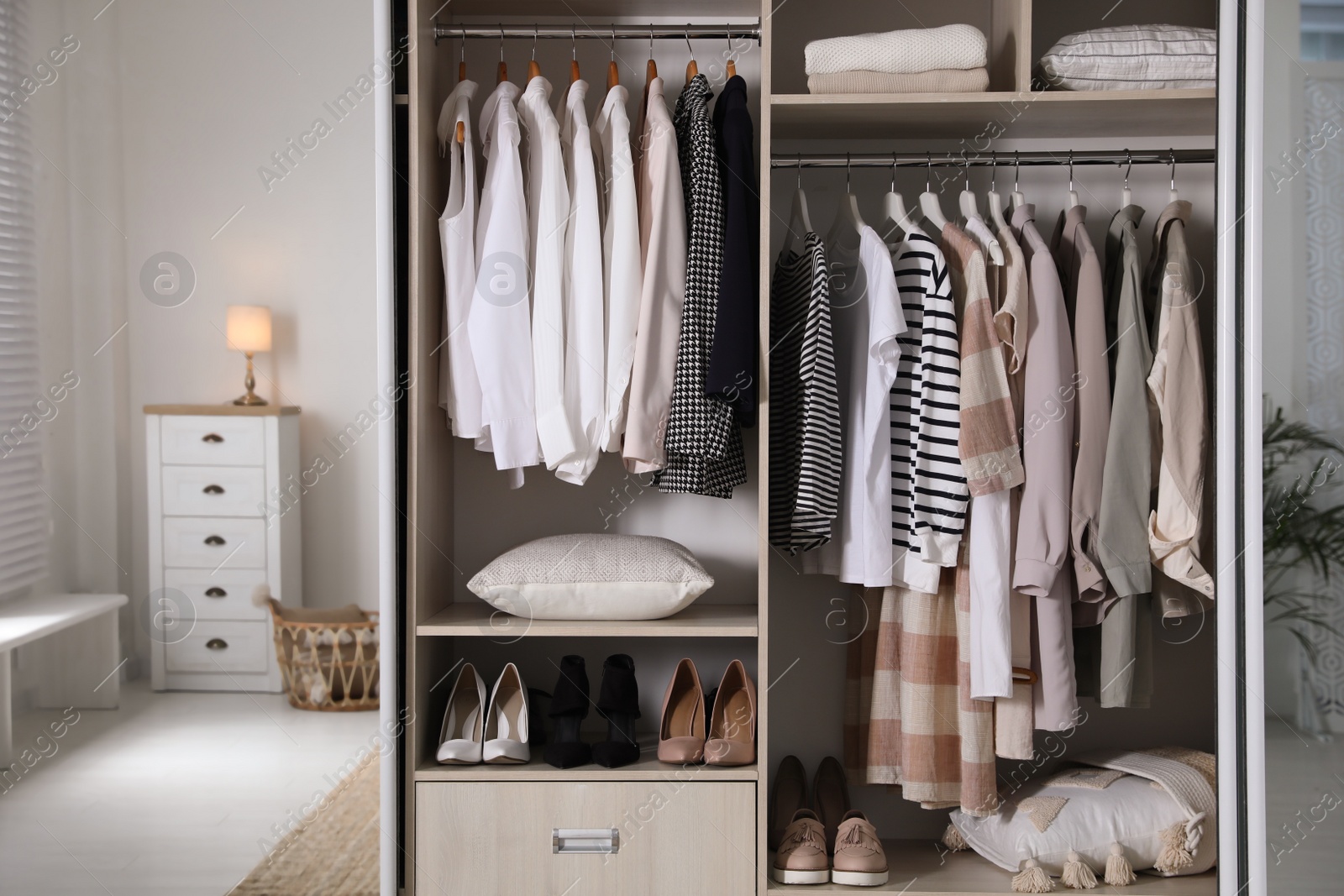 Photo of Wardrobe closet with different stylish clothes, shoes and home stuff in room