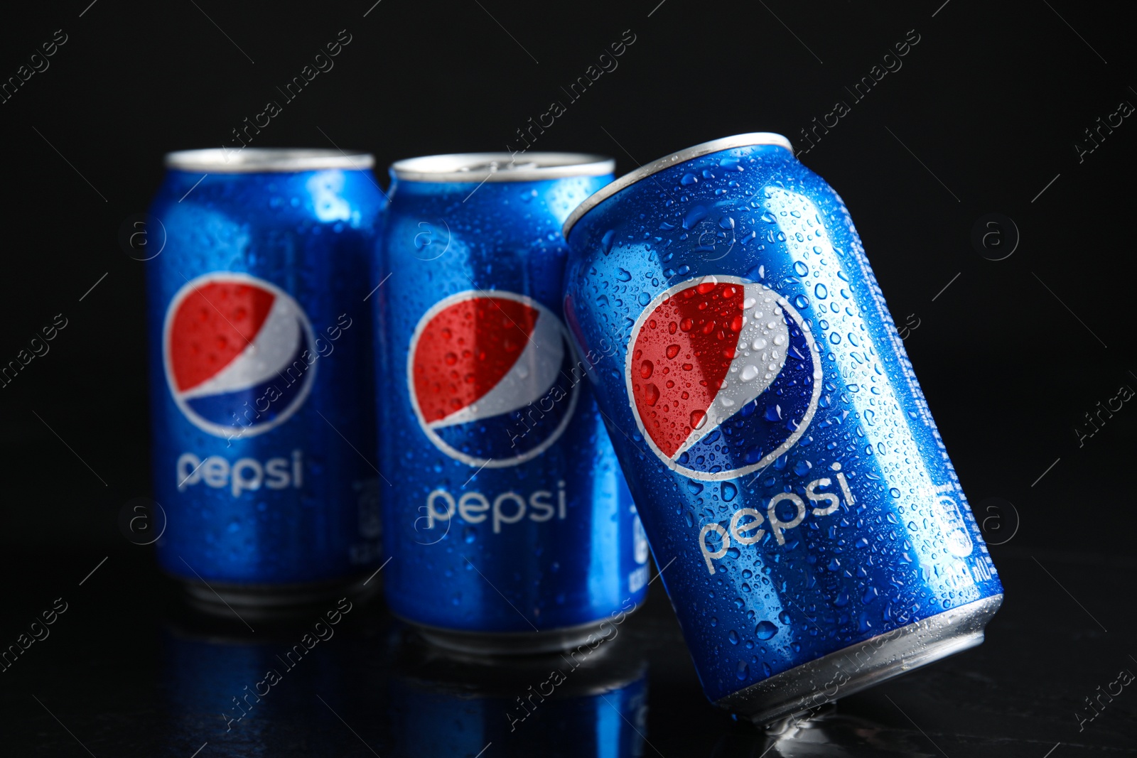 Photo of MYKOLAIV, UKRAINE - FEBRUARY 08, 2021: Cans of Pepsi with water drops on black table