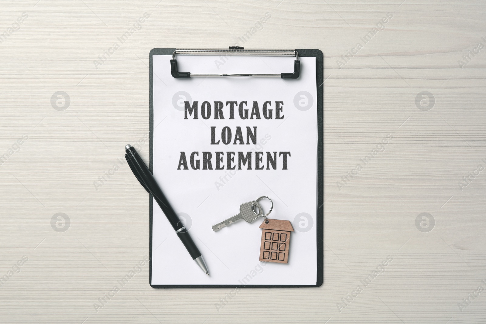 Image of Mortgage loan agreement, house key and pen on white wooden table, top view