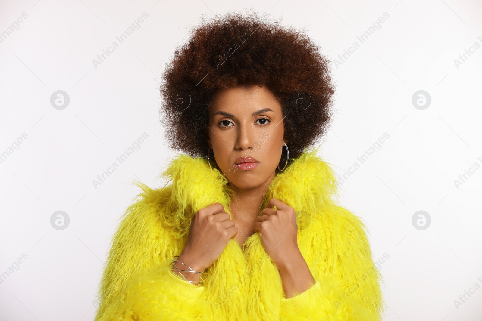 Photo of Portrait of beautiful young woman in stylish yellow fur coat on white background