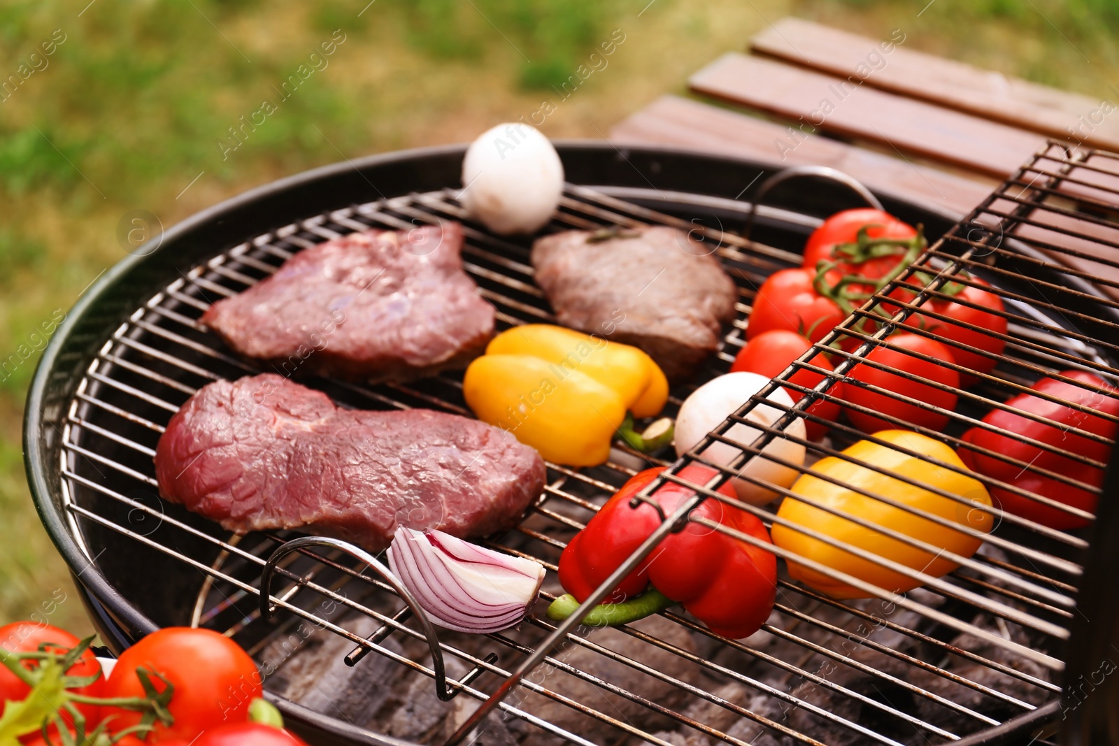 Photo of Modern grill with meat and vegetables outdoors, closeup