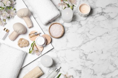 Photo of Flat lay composition with spa essentials on white marble background. Space for text