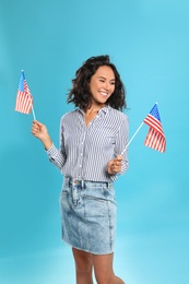 Photo of happy young woman with American flags on blue background