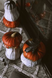 Photo of Colorful pumpkins on rug near fireplace, above view. Halloween decorations