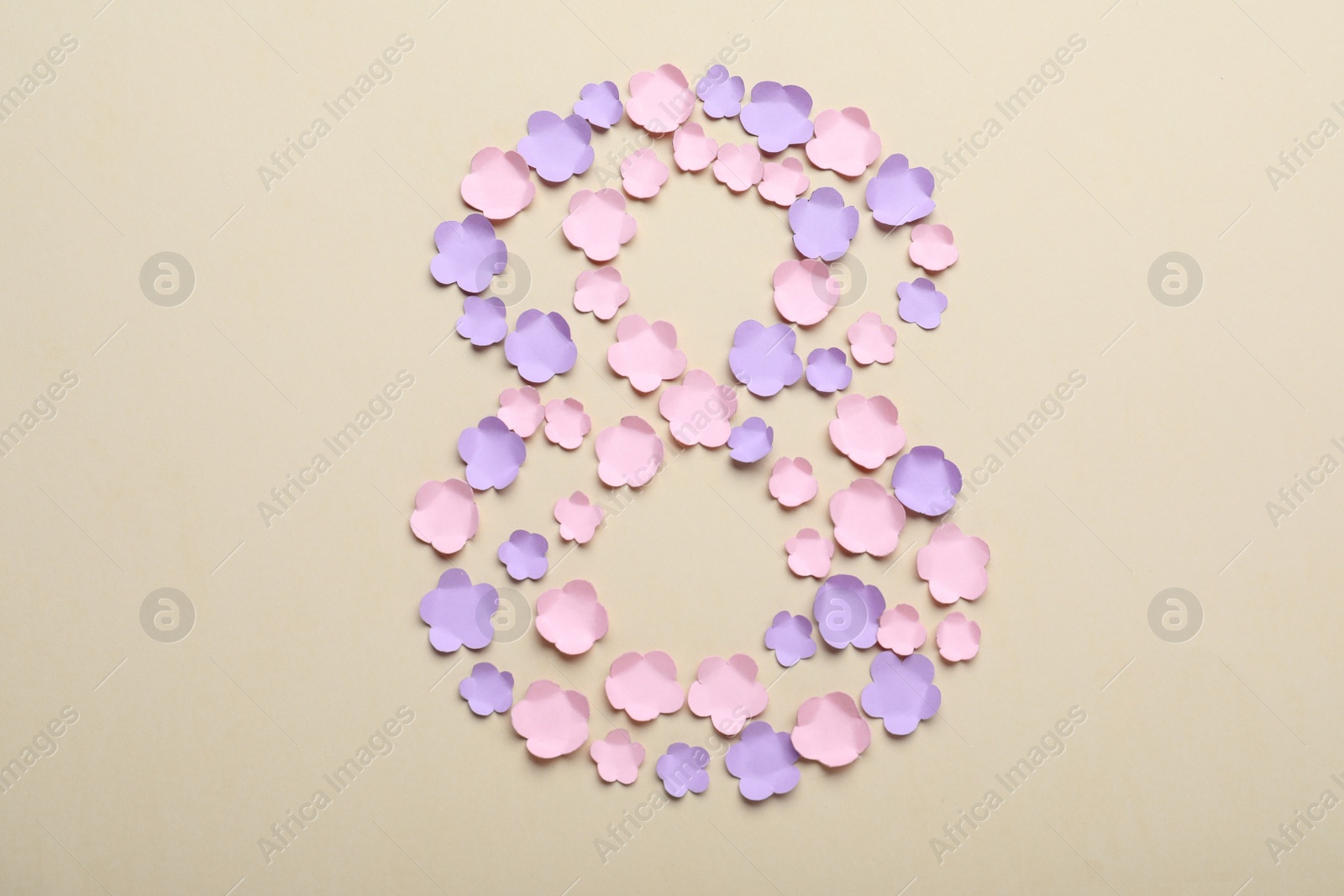 Photo of Number 8 made with paper flowers on beige background, flat lay. International Women's day