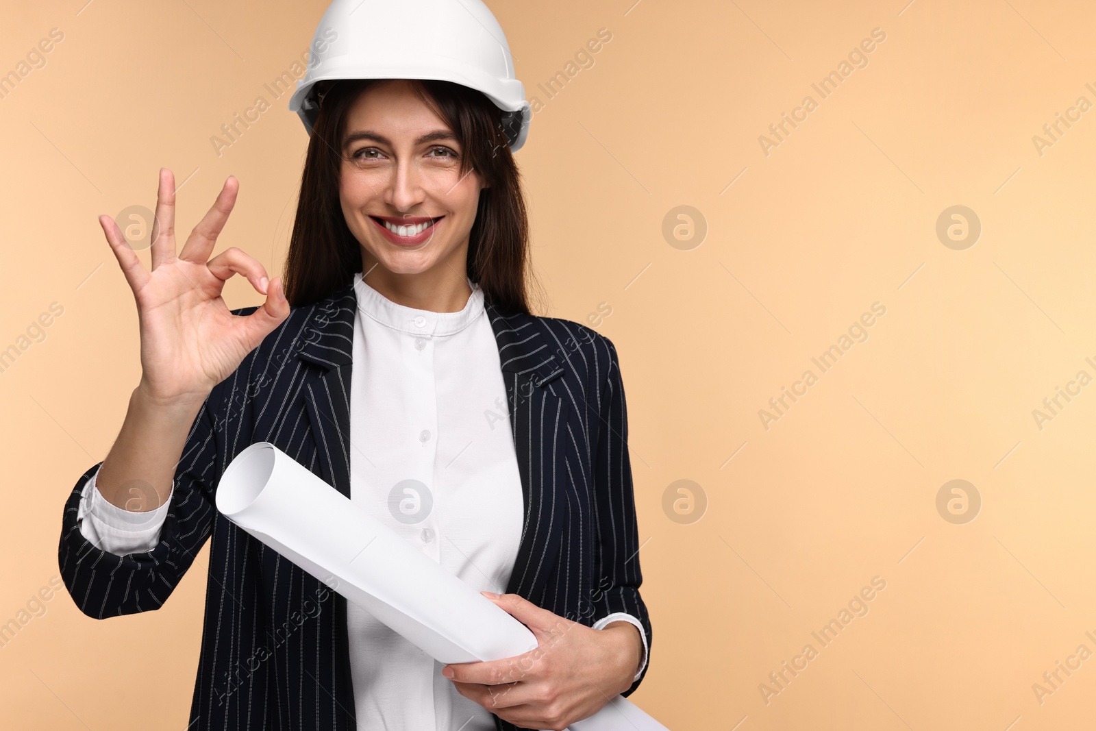 Photo of Architect in hard hat with draft showing ok gesture on beige background, space for text