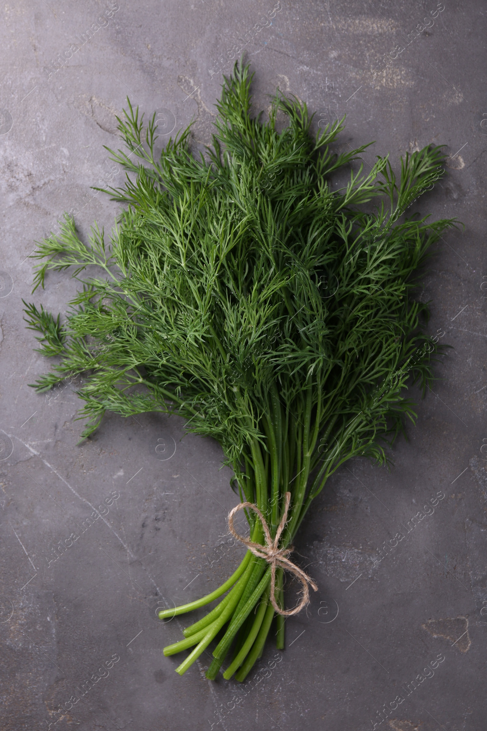 Photo of Bunch of fresh dill on grey textured table, top view