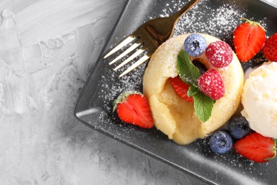 Photo of Tasty vanilla fondant with white chocolate, berries and ice cream on light grey table, top view. Space for text