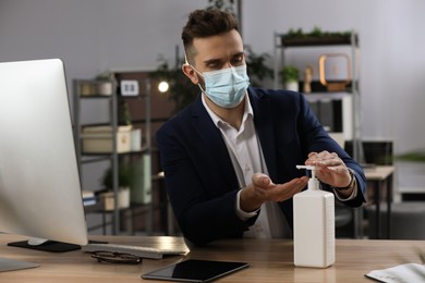 Man applying hand sanitizer at workplace in office. Personal hygiene during Coronavirus pandemic